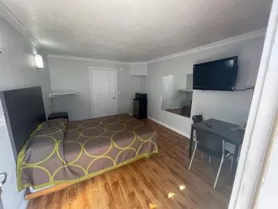 a bedroom with a bed and a desk in it at Seaway Motel in Los Angeles