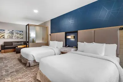a hotel room with two beds and a couch at SpringHill Suites by Marriott Anaheim Placentia Fullerton in Placentia