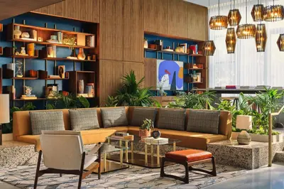 a lobby with a couch and a table and chairs at The Hollywood Grande, Autograph Collection in Los Angeles