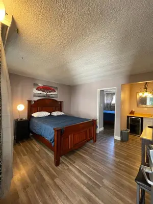 a bedroom with a bed with a blue comforter at LA Adventurer Hotel in Inglewood