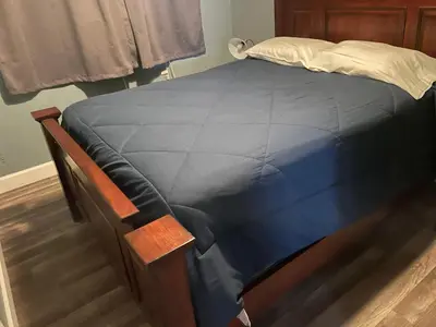 a bed with a blue comforter on top of it at LA Adventurer Hotel in Inglewood