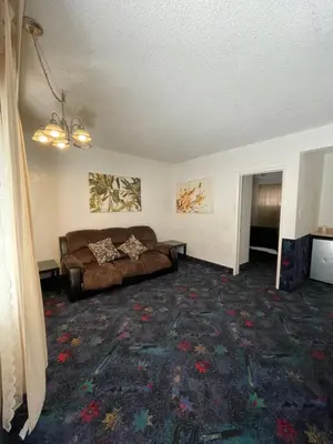 a living room with a couch and a rug at LA Adventurer Hotel in Inglewood