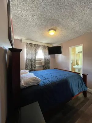 a bedroom with a blue bed and a window at LA Adventurer Hotel in Inglewood