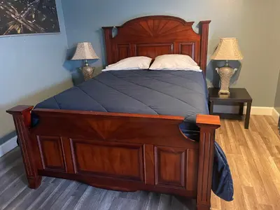 a bedroom with a large wooden bed with two lamps at LA Adventurer Hotel in Inglewood