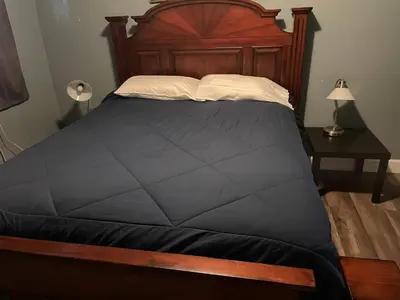 a bedroom with a large bed with a wooden headboard at LA Adventurer Hotel in Inglewood