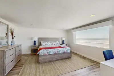 a bedroom with a bed and a large window at Savor the View in Oxnard