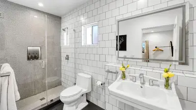 a white bathroom with a toilet and a sink at Art Deco by AvantStay in Los Angeles