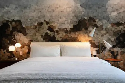 a bedroom with a white bed and a wall with mosaic at Le Meridien Pasadena Arcadia in Arcadia