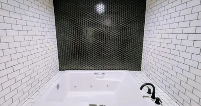 a white tiled bathroom with a tub with a window at The Bell Vista in Burbank