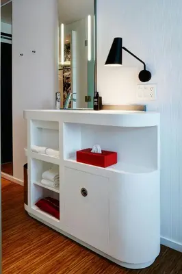 a white bathroom vanity with a mirror and a red box at citizenM Los Angeles Downtown in Los Angeles