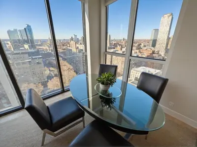 a glass table and chairs in a room with a large window at Modern Luxury Apartments in the Heart of Los Angeles in Los Angeles