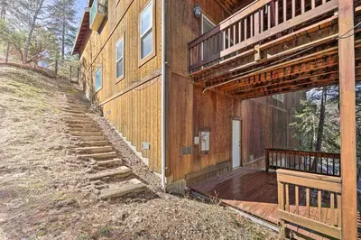 a wooden house with a staircase leading up to a porch at Wraparound Deck Woodland Cabin in Lake Arrowhead in Lake Arrowhead