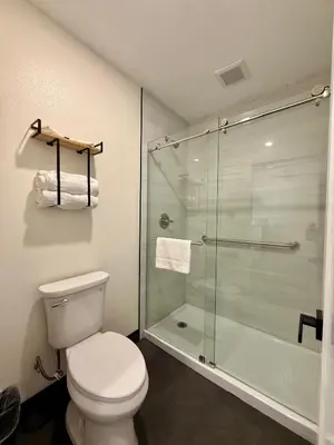 a bathroom with a toilet and a glass shower at SOFI MOTEL in Los Angeles