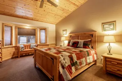 a bedroom with a wooden bed in a room at Little Cubs Cabin #1986 by Big Bear Vacations in Big Bear Lake