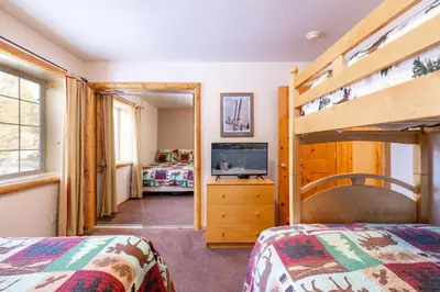 a bedroom with two bunk beds and a television at Little Cubs Cabin #1986 by Big Bear Vacations in Big Bear Lake