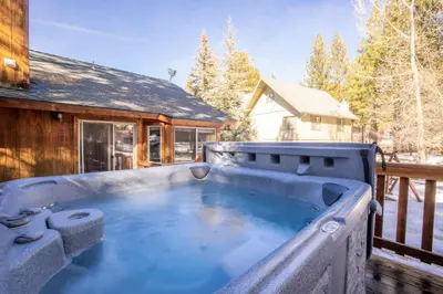 a hot tub on the deck of a house at Little Cubs Cabin #1986 by Big Bear Vacations in Big Bear Lake
