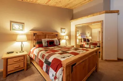 a bedroom with a wooden bed and a large mirror at Little Cubs Cabin #1986 by Big Bear Vacations in Big Bear Lake