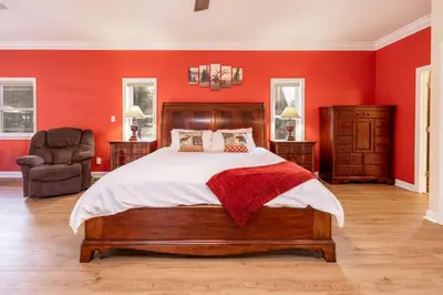 a bedroom with a large bed with red walls at The Grand Chalet #1989 by Big Bear Vacations in Big Bear Lake