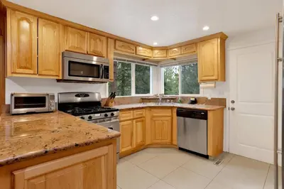 a kitchen with wooden cabinets and a stove top oven at Conklin Paradise #1993 by Big Bear Vacations in Big Bear Lake