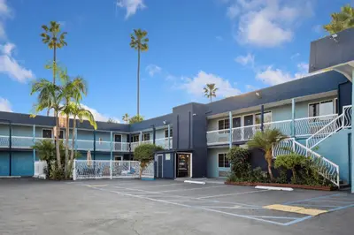 a building with palm trees in a parking lot at Hotel H-Wood in Los Angeles