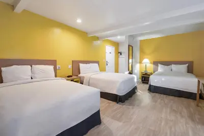 a hotel room with two beds and yellow walls at Hotel H-Wood in Los Angeles