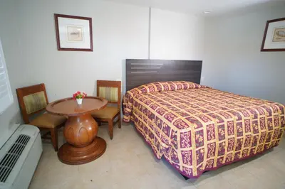 a bedroom with a bed and a table and chairs at The Fly Inn Motel in Lynwood