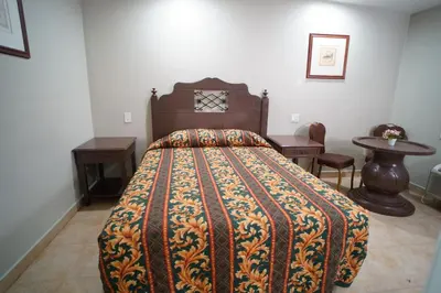 a bedroom with a bed and a desk and a table at The Fly Inn Motel in Lynwood