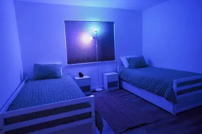 a blue room with two beds and a window at Pine Mountain Club Villa with Sauna, Deck and Views! in Pine Mountain Club