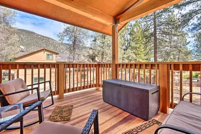a porch with chairs and a television on a deck at Pine Mountain Club Villa with Sauna, Deck and Views! in Pine Mountain Club