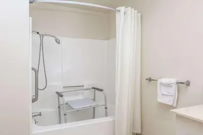 a bathroom with a shower and a white tub at Super 8 by Wyndham Bakersfield/Central in Bakersfield
