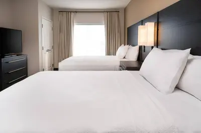 a hotel room with two beds and a television at Residence Inn by Marriott Loma Linda Redlands in Redlands