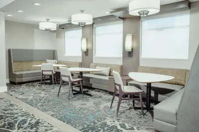 a waiting room with tables and chairs and windows at Residence Inn by Marriott Loma Linda Redlands in Redlands