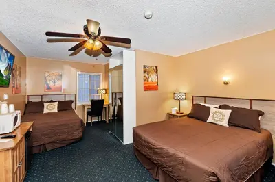 a hotel room with two beds and a ceiling fan at Robinhood Resort in Big Bear Lake