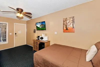 a bedroom with a bed and a ceiling fan at Robinhood Resort in Big Bear Lake