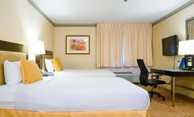 a hotel room with two beds and a desk at Studio 6 Anaheim Hills CA in Anaheim