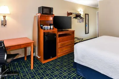 a hotel room with a bed and a desk and a television at SureStay Hotel by Best Western Ontario Airport in Ontario