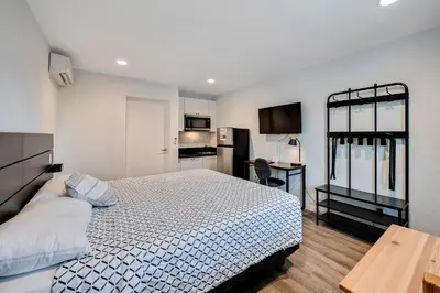 a small bedroom with a bed and a kitchen at Unik Motel in Harbor City