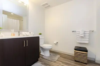a bathroom with a toilet and a sink and a mirror at Luxury Highrise Living Downtown LA in Los Angeles