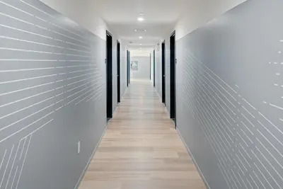a long hallway with white walls and wooden floors at The Metric - Los Angeles Downtown in Los Angeles