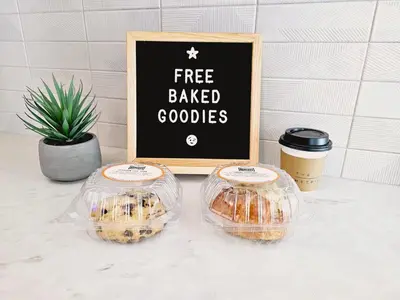 two bags of donuts and a sign with free baked goods at The Metric - Los Angeles Downtown in Los Angeles