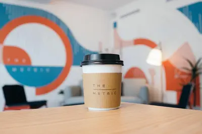 a coffee cup sitting on top of a table at The Metric - Los Angeles Downtown in Los Angeles