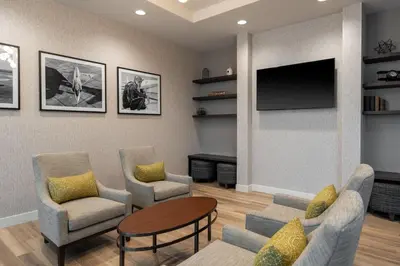 a living room with two chairs and a tv at Residence Inn by Marriott Lancaster Palmdale in Lancaster