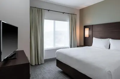 a hotel room with a bed and a large window at Residence Inn by Marriott Lancaster Palmdale in Lancaster