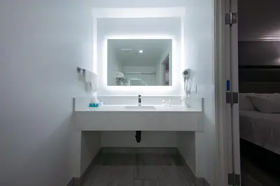a bathroom with a sink and a mirror at Travelodge Inn & Suites by Wyndham West Covina in West Covina