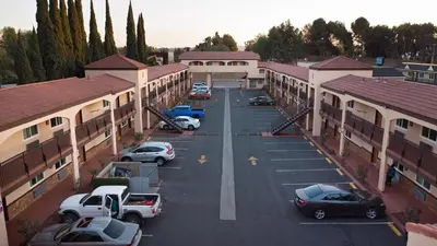 an aerial view of a parking lot between buildings at Travelodge Inn & Suites by Wyndham West Covina in West Covina