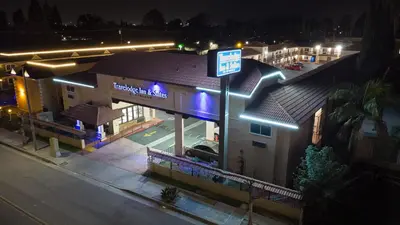 a building with a sign in front of it at night at Travelodge Inn & Suites by Wyndham West Covina in West Covina