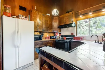 a kitchen with wooden cabinets and a white refrigerator at Alpine Dream in Crestline
