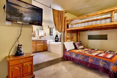 a bedroom with a bunk bed and a bathroom at Moose Manor #2012 by Big Bear Vacations in Big Bear Lake