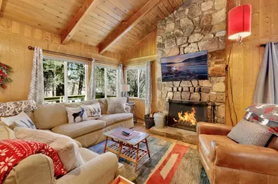 a living room with couches and a stone fireplace at Marin Getaway #2013 by Big Bear Vacations in Big Bear Lake