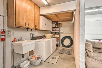 a small kitchen with a sink and a washer and dryer at Boho-Chic Home with Game Room Near Lake Gregory! in Crestline